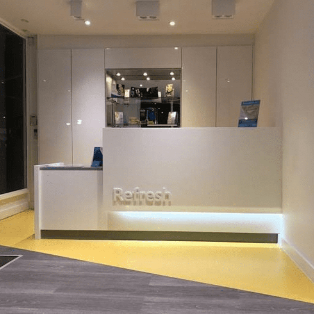 Bespoke Dental Reception Desk in white and grey corian with logo and lighting